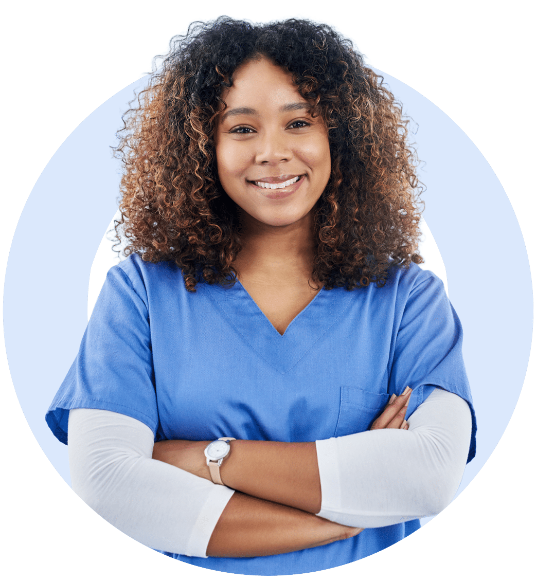 Woman in scrubs smiling with arms crossed