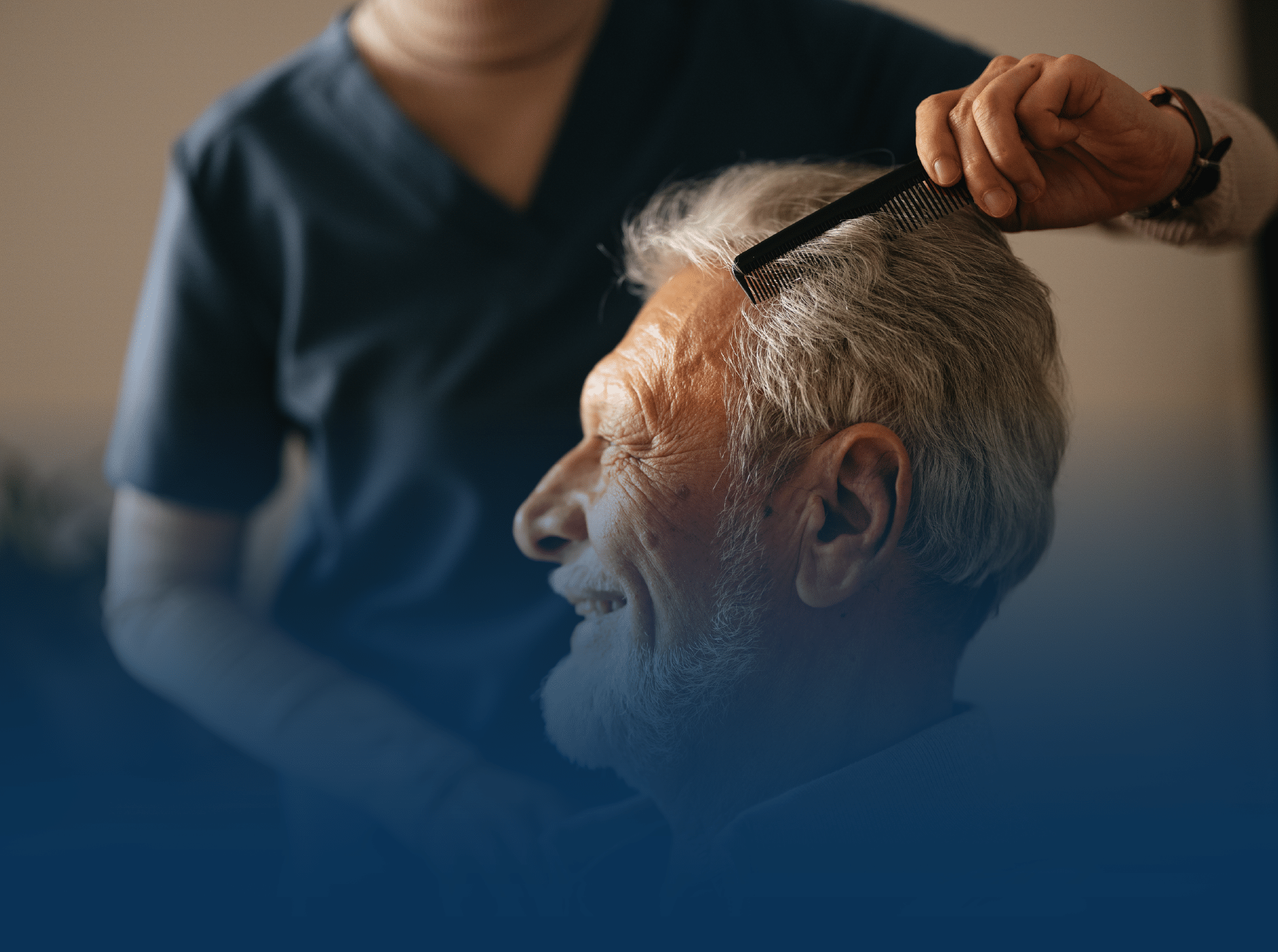 Older man getting hair combed by caregiver
