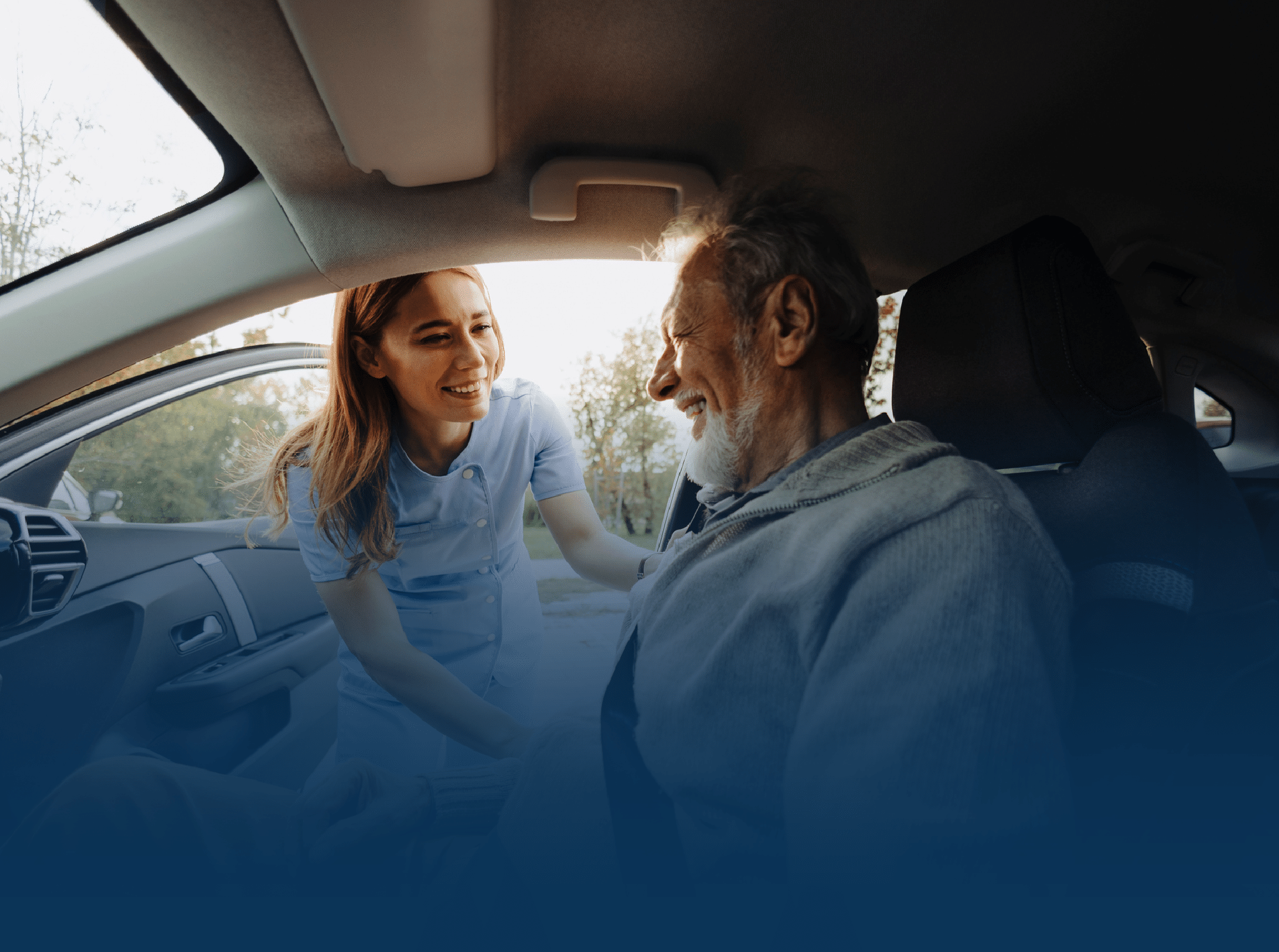 Woman in scrubs helping older man into car