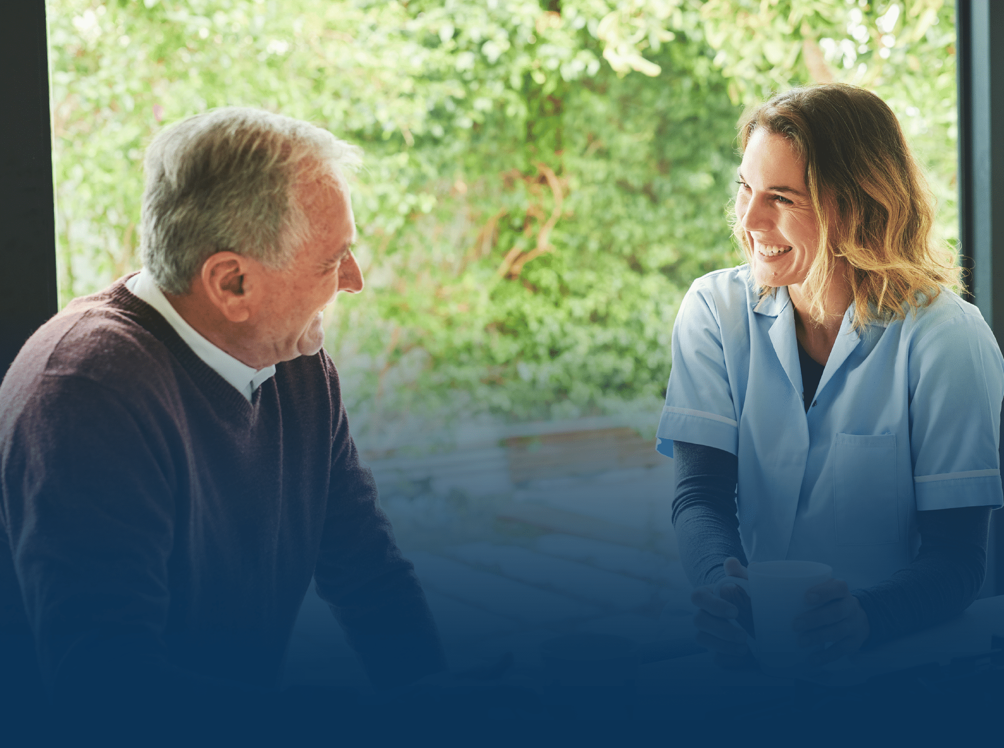 Smiling caregiver talking to older male