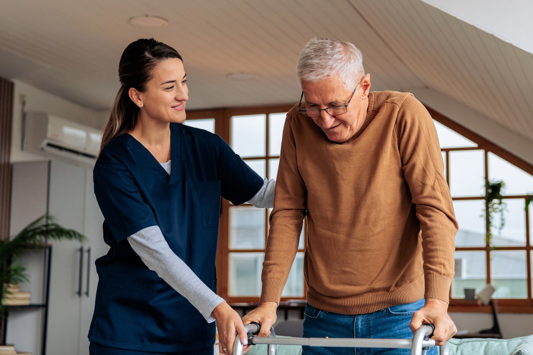Caregiver helping older man with walker