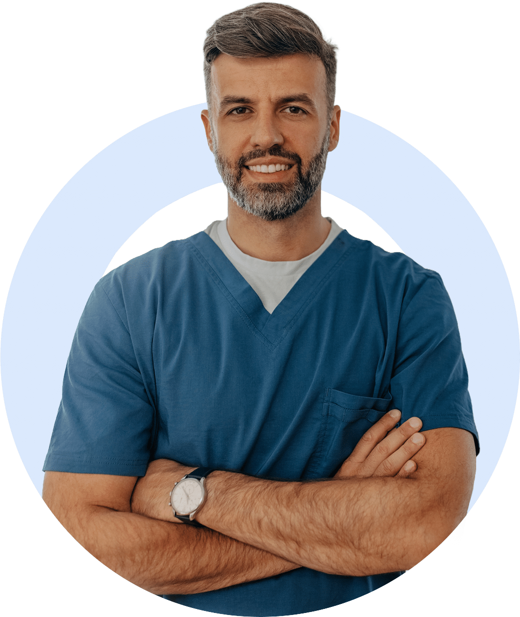 Smiling man in scrubs with arms crossed
